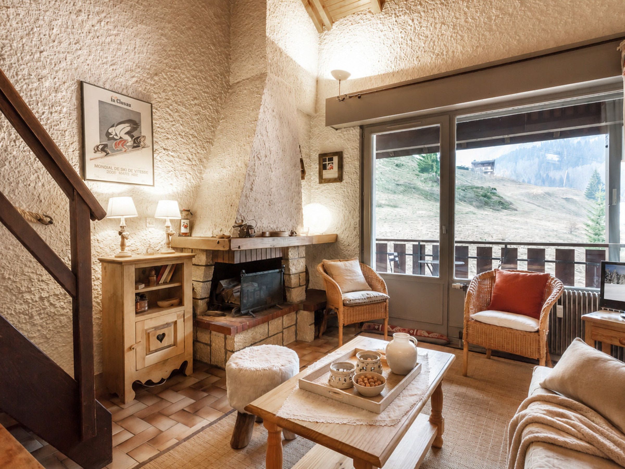 Un salon chaleureux avec une cheminée, des meubles en bois et une vue sur un paysage montagneux.