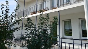 Un bâtiment à deux étages, doté de balcons, d’un toit en tuiles et d’une fenêtre visible au deuxième étage.