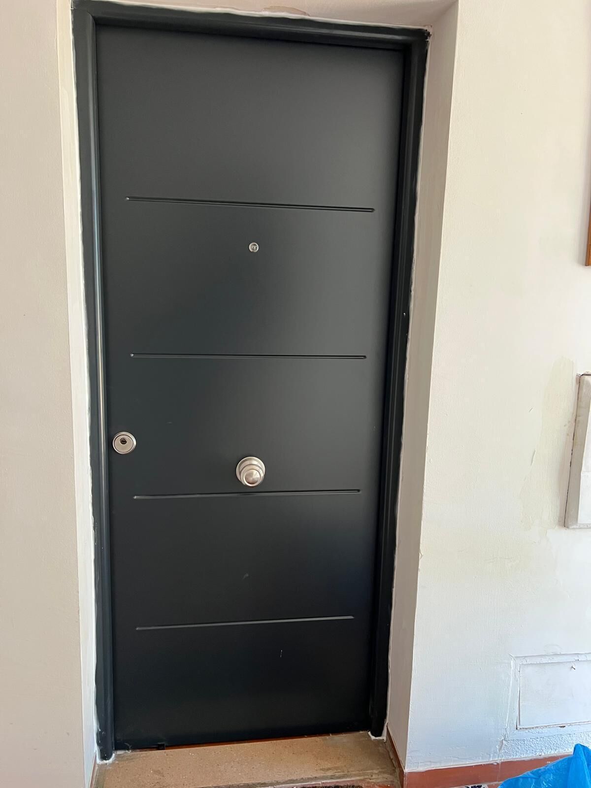 A closed black door with a keyhole and two round handles.