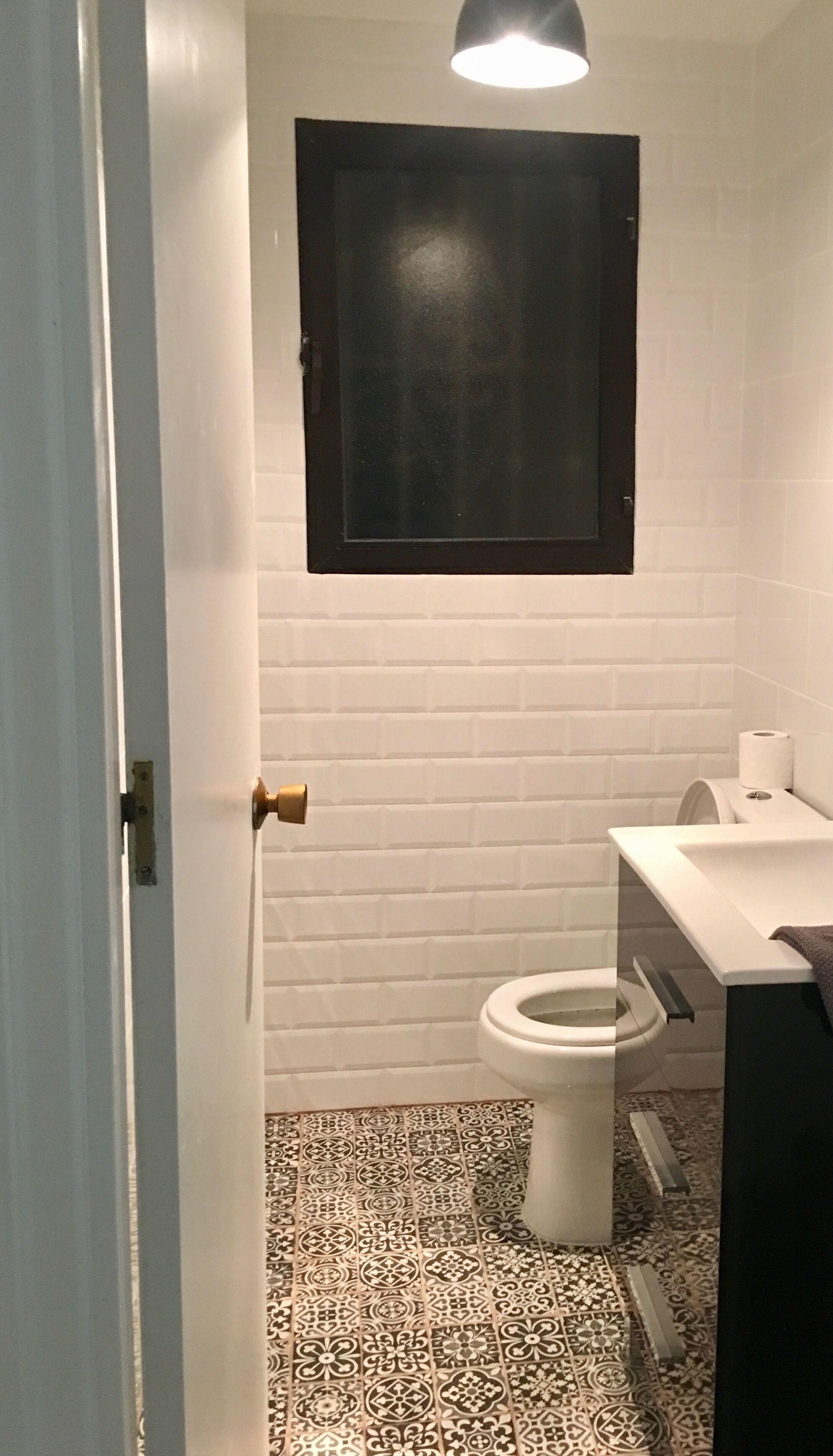 A bathroom with a toilet, a sink, and a cabinet.