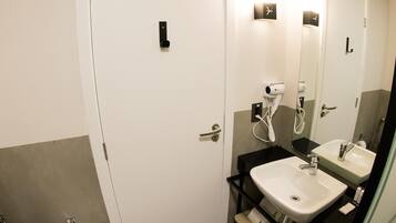 A modern bathroom with a white toilet, a sink, and a mirror.