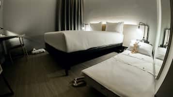 Quarto de hotel com uma cama, uma mesa e uma cadeira.
