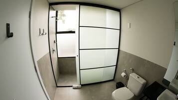 A modern bathroom with a toilet, sink, and shower area.