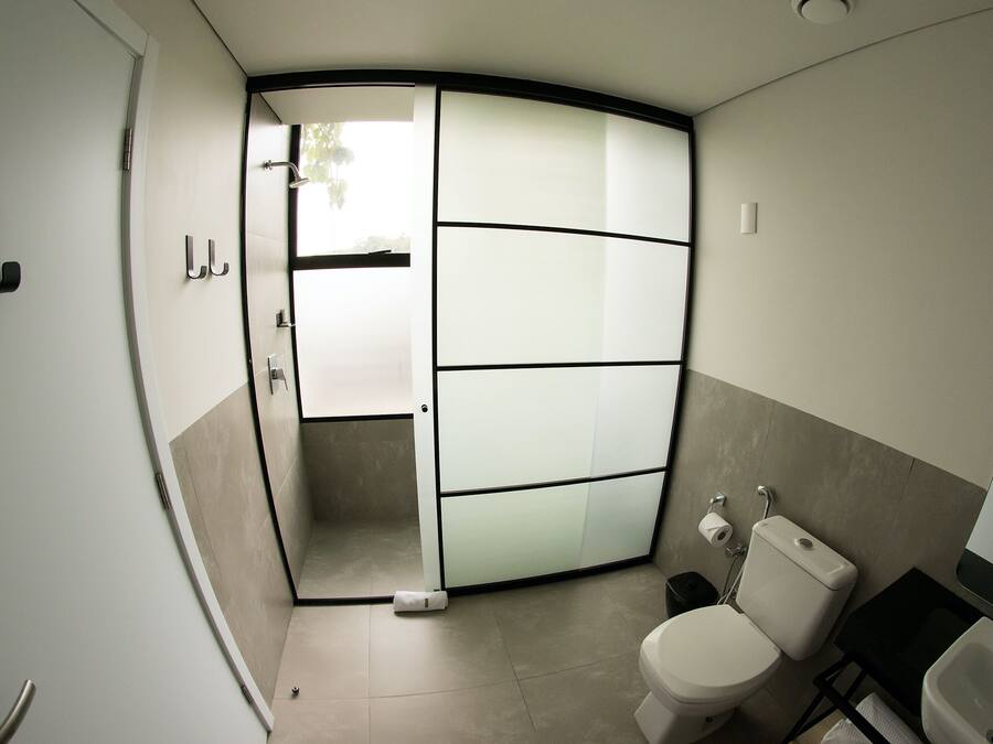 A modern bathroom with a toilet, sink, and shower area.