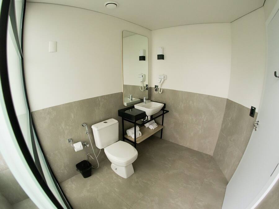 Un baño con inodoro, lavamanos y espejo.