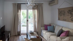 Ein Wohnzimmer mit einer Couch, einem Couchtisch, einem Fernseher und einer Kristallleuchtre.
