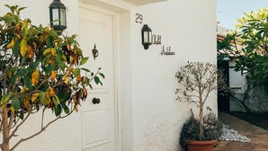 Ein weißes Gebäude mit einer Tür, auf der „29“ steht, und dem Schriftzug „Andalucía“ an der Wand.