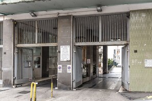 Une entrée fermée par un portail, agrémentée d’un panneau indiquant une limite de hauteur et interdisant le stationnement.