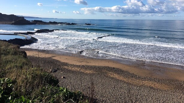 A coastal beach with rocky shores, clear skies, and a distant view of the sea. - Peaceful and comfortable HOUSE with COUNTRYSIDE views, 5 min drive to beach (Stratton, Bude)