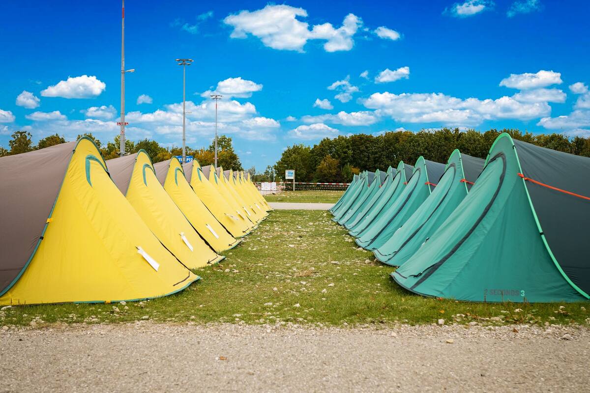 A row of tents in a campsite with a clear sky.