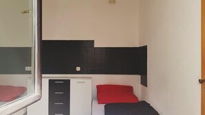 A small, compact room with a bed, a desk, and a window. - Monteurwohnungen Viernheim (Viernheim)