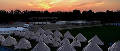 A row of tents with a sunset in the background.
