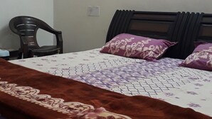 Un dormitorio con una cama, una silla y una pared lisa.