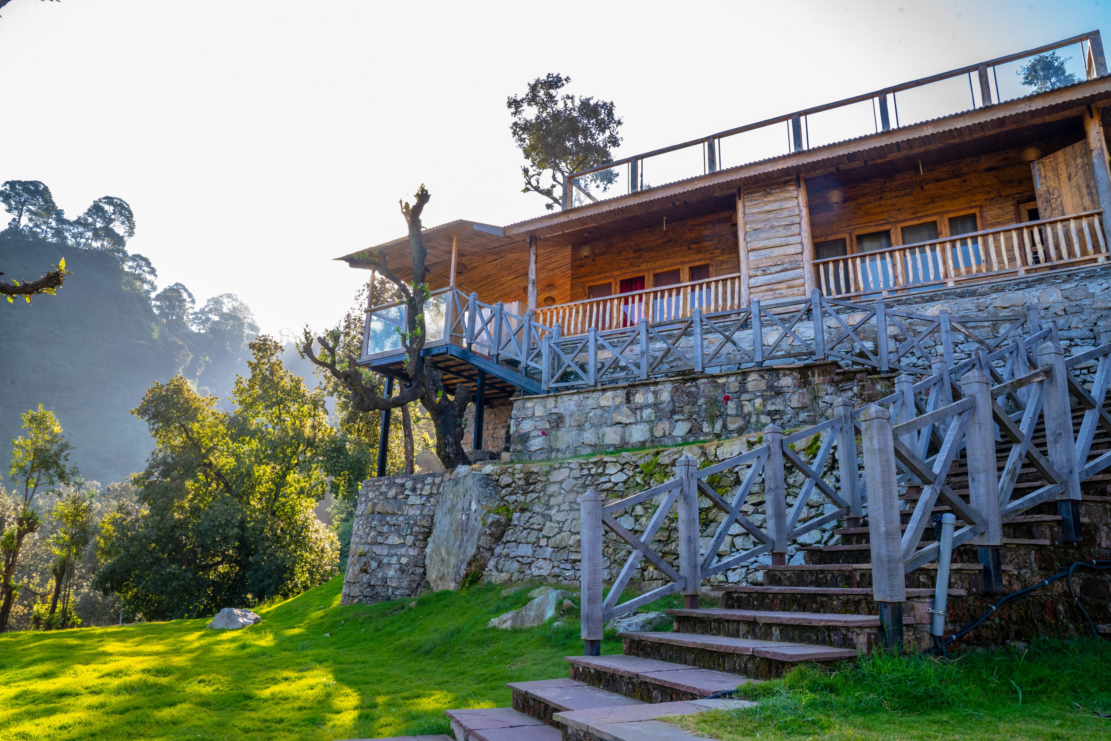 A wooden cabin with a stone staircase leading up to a balcony.