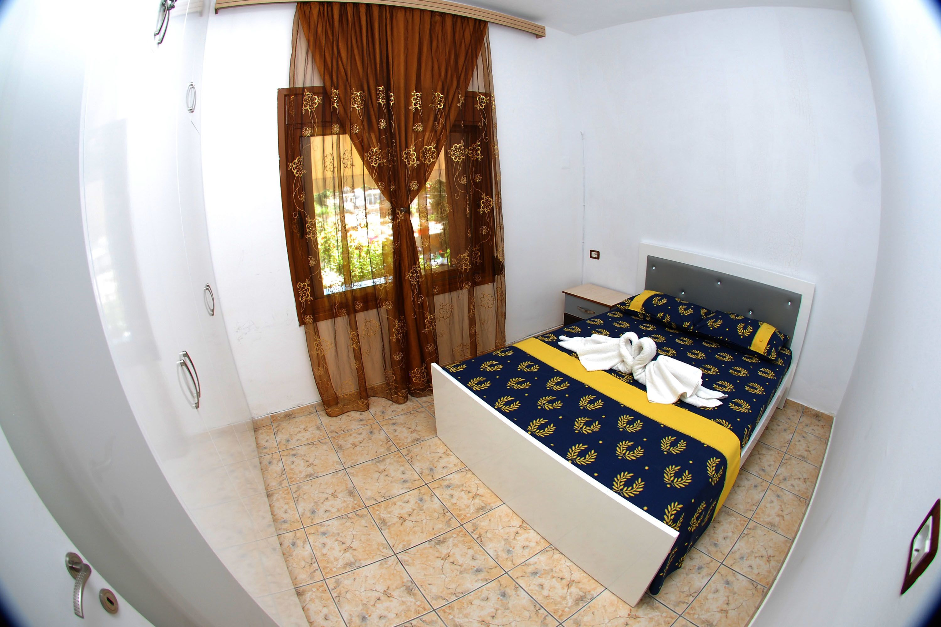 Un dormitorio con cama, cortinas y ventana.