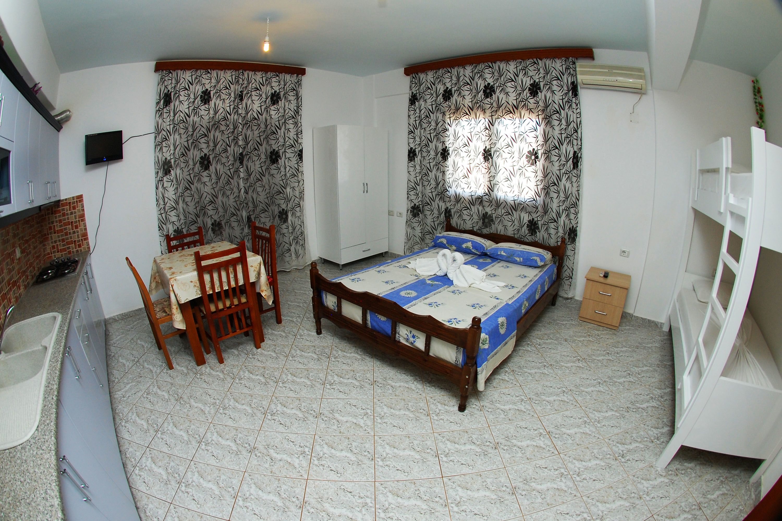 Un dormitorio con cama, escritorio, silla, armario y baño.