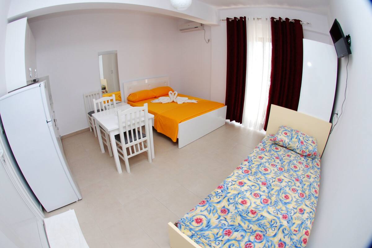 A bedroom with a bed, a desk, and a chair.