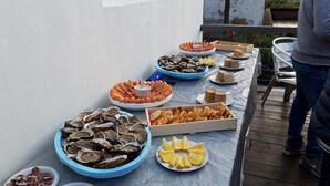 Una mesa con diversos alimentos, entre ellos ostras, camarones y pan.