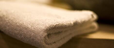 A folded white towel on a wooden surface.