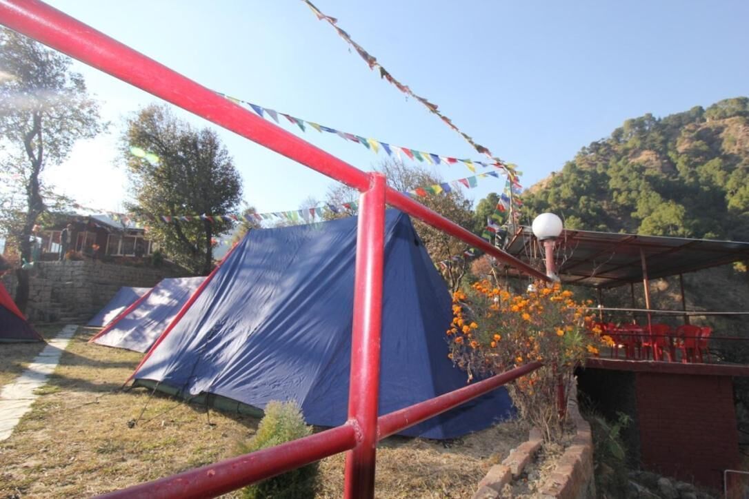Un campamento con tiendas de campaña y una estructura metálica roja.