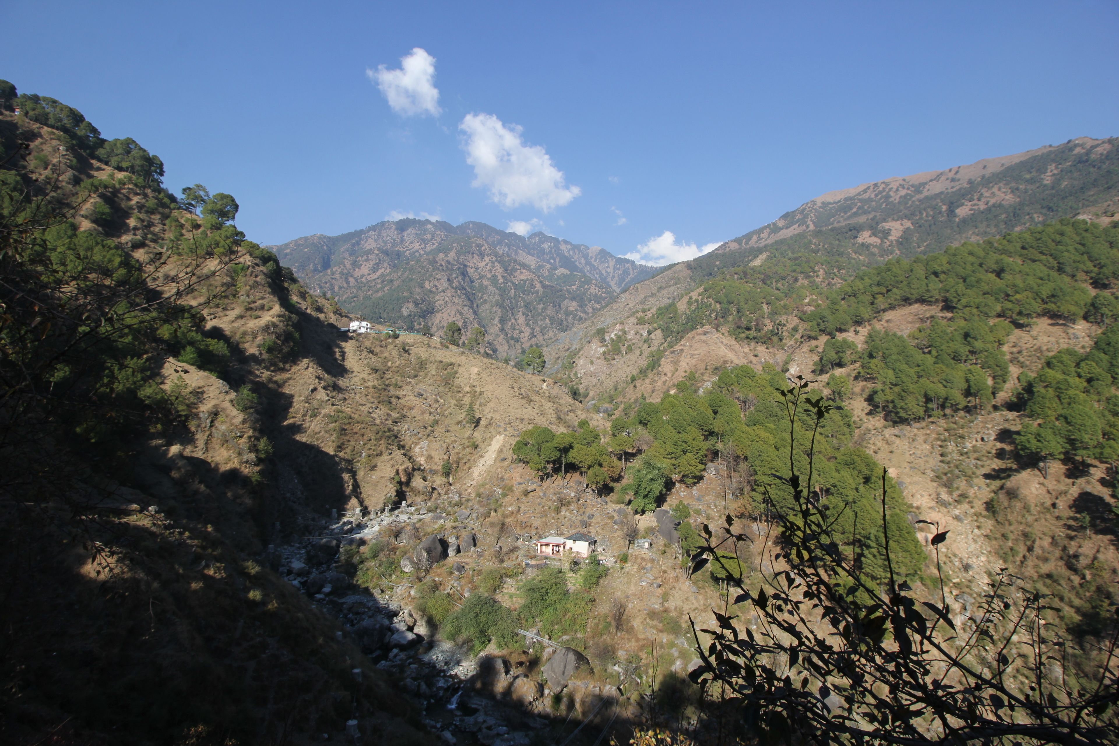 Un paysage montagneux avec un petit bâtiment niché au milieu des collines.