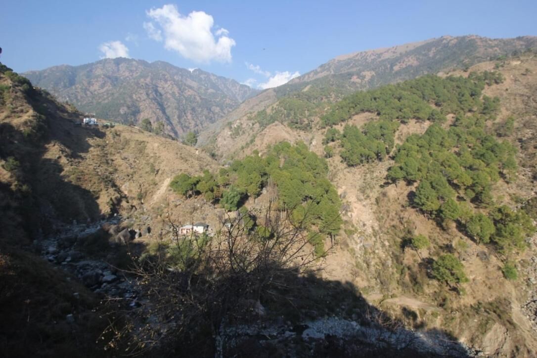 A mountainous landscape with a small building nestled among the hills.