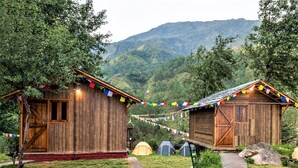 Deux cabanes en bois offrant une vue sur un paysage montagneux.