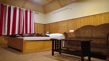 A room with a wooden bunk bed, a brown sofa, and a small table.