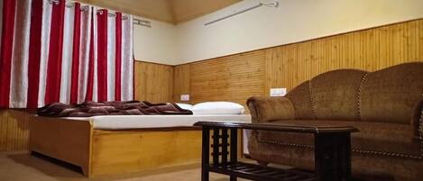 A room with a wooden bunk bed, a brown sofa, and a small table.