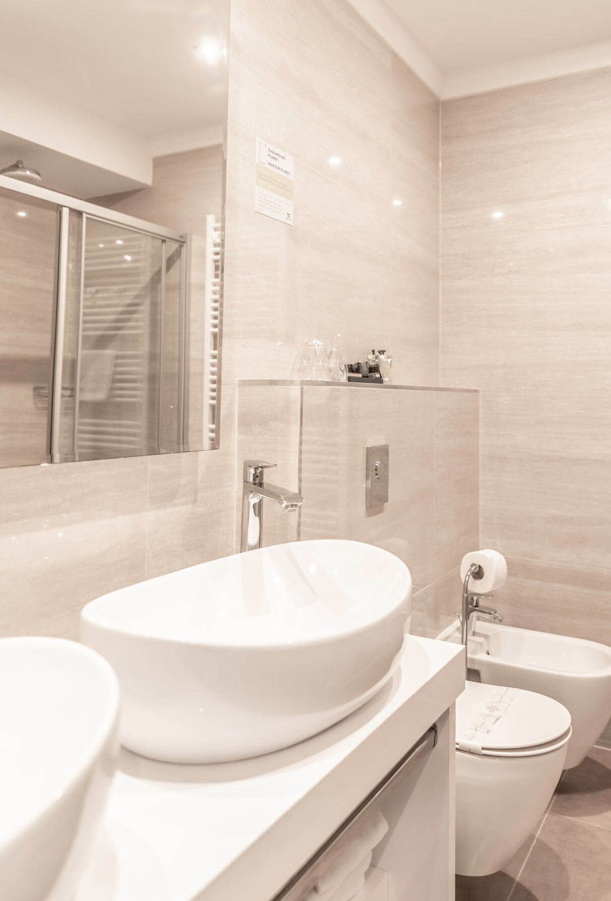 Un baño moderno con un lavamanos grande, inodoro y zona de ducha.