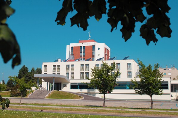 Un bâtiment moderne doté d’un toit plat, de grandes fenêtres et d’une entrée centrale.