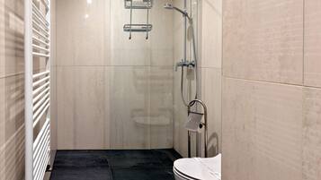 Une salle de bain moderne avec une douche à parois de verre, des toilettes et un porte-serviettes.