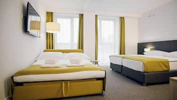 Habitación de hotel con dos camas, un espejo grande y una ventana con cortinas.