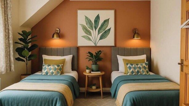A room with two beds, each with a headboard, a small side table, a potted plant, and a framed artwork on the wall. - Self Catering Holidays in the uk (Blaenau Ffestiniog)