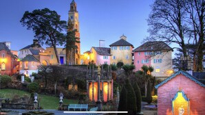 A quaint village with colorful buildings, a prominent church, and a well-maintained garden. - Self Catering Holidays in the uk (Blaenau Ffestiniog)