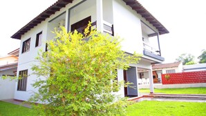 A two-story house with a balcony, a red fence, and a green lawn. - Residencial Mandino - Quality, conformity and safety (Jardim Iguaçú)