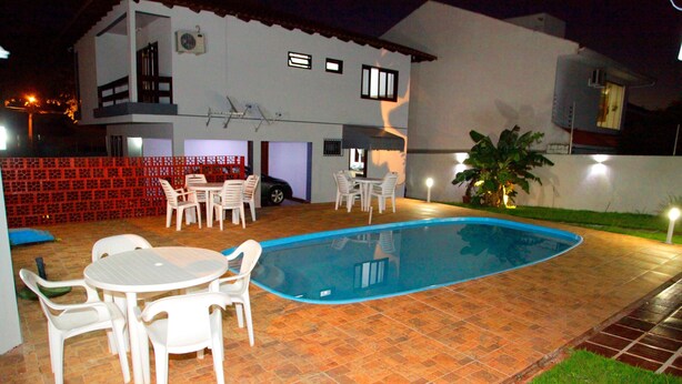 A two-story house with a swimming pool, patio furniture, and a red fence. - Residencial Mandino - Quality, conformity and safety (Jardim Iguaçú)