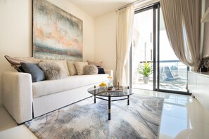 Deluxe appartement, 1 tweepersoonsbed met slaapbank, uitzicht op de stad | Woonruimte | Flatscreentelevisie