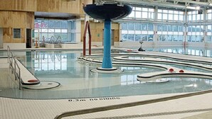 Piscina interior con fuente central y varias pistas de natación.
