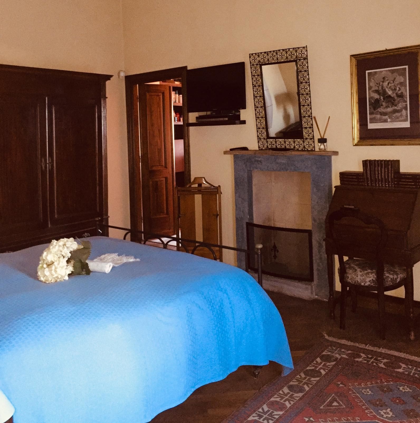 Une pièce comprenant un lit, une cheminée, un bureau et une chaise.
