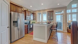 Una cocina moderna con armarios de madera, electrodomésticos de acero inoxidable y una isla central.