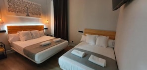 A hotel room with two beds, a wall-mounted TV, and a decorative tree painting. - CH Lemon Rooms By HEBEROOMS (Madrid)