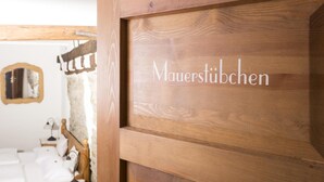 Uma porta de madeira com o texto 'Mauerstuben', indicando um quarto ou área.