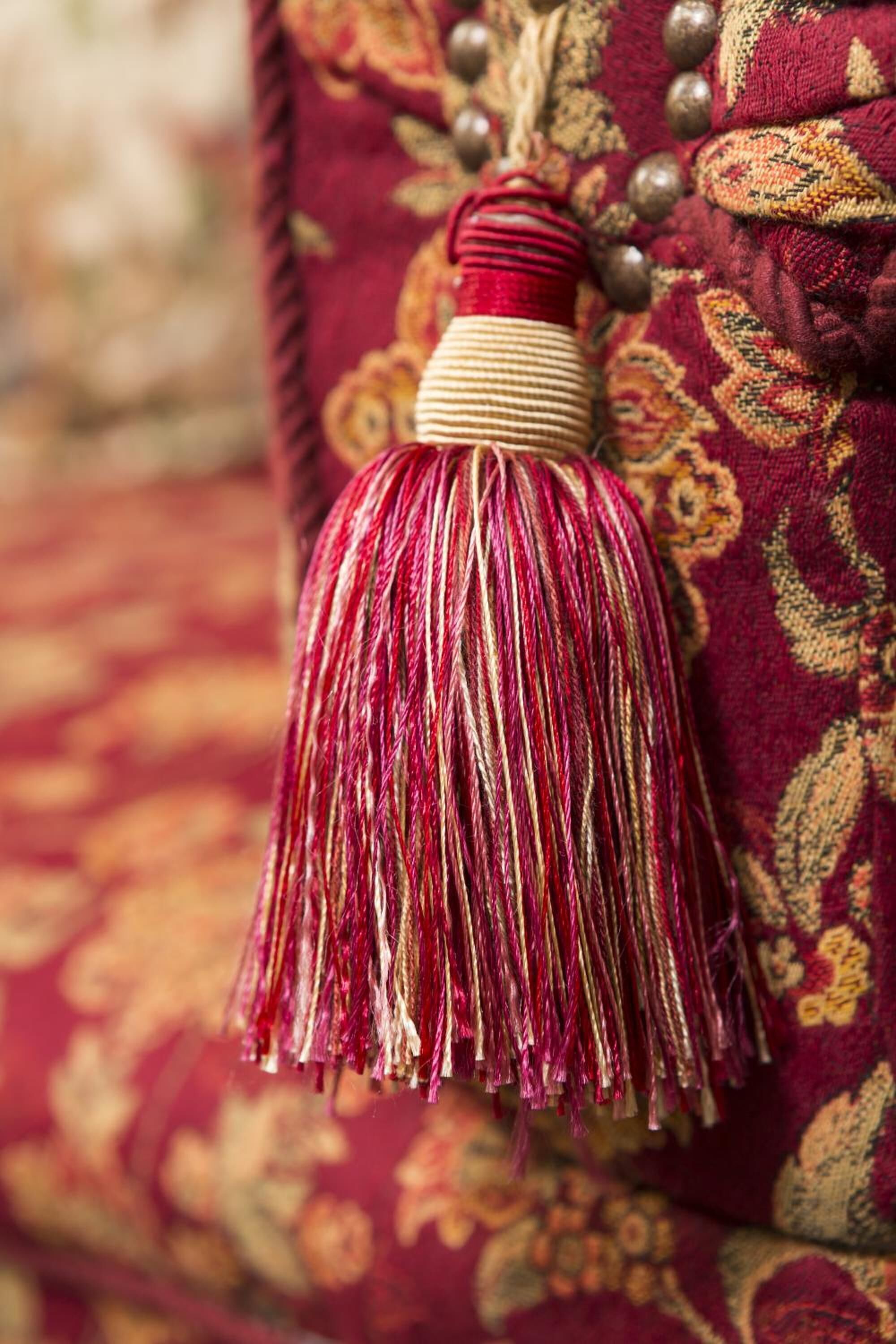 A close-up of a decorative tassel hanging from a fabric with a floral pattern.
