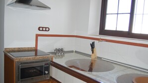 A kitchen with a built-in oven, a sink, and a window. - El Garrotal Rural Cottage (Sevilla)