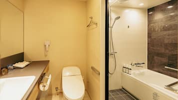 Une salle de bain moderne équipée de toilettes, d’un lavabo et d’une baignoire.