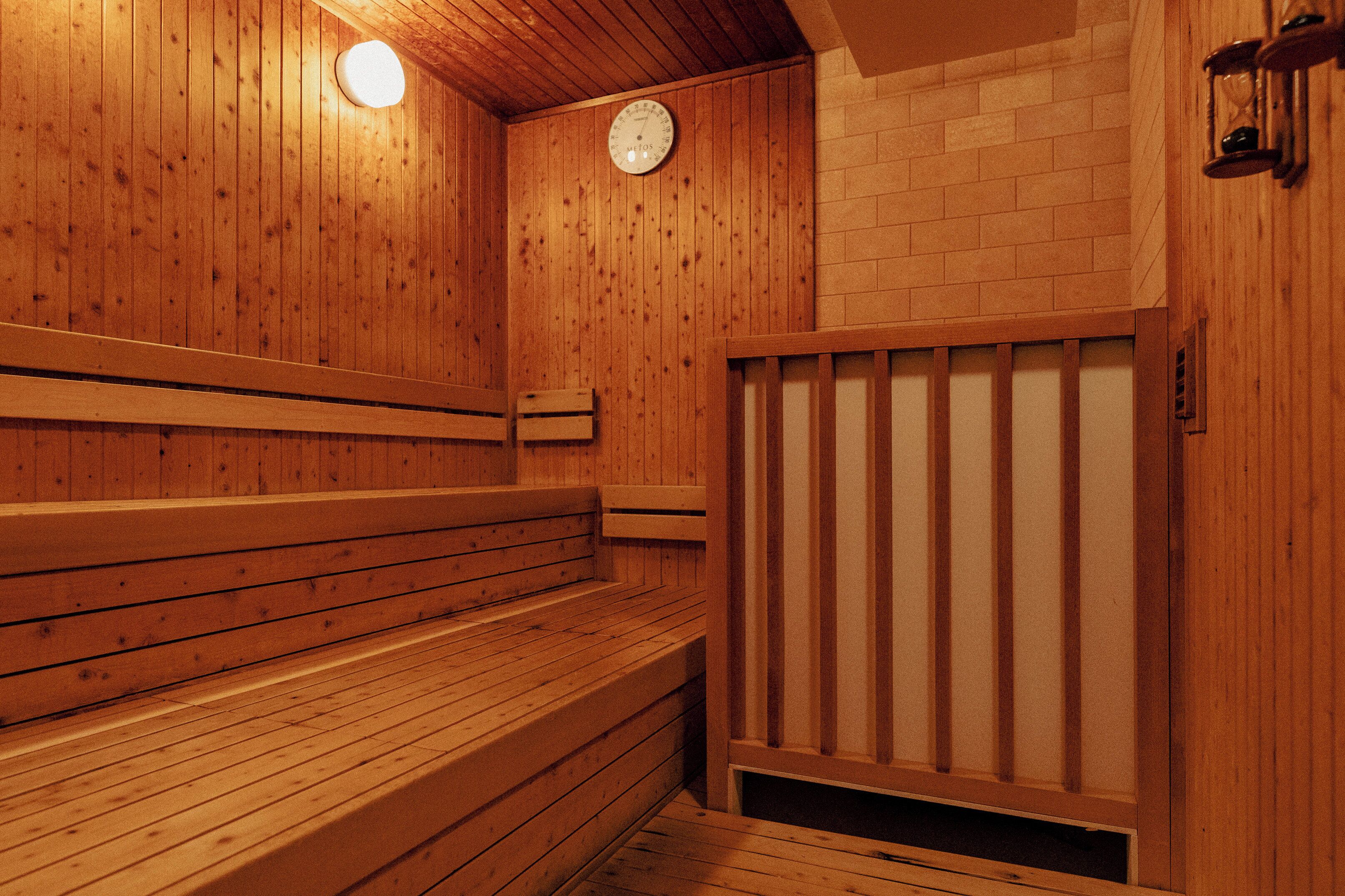 Un sauna avec des bancs en bois et une horloge fixée au mur.