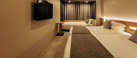 A hotel room with two beds, a flat-screen TV mounted on the wall, a bedside table, and a large window with curtains.