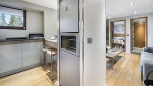 Una cocina moderna con horno empotrado y comedor con mesa y sillas.