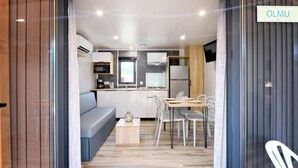 A modern kitchen with white cabinets, a built-in oven, and a microwave. - Camping Bella Vista (Calvi)